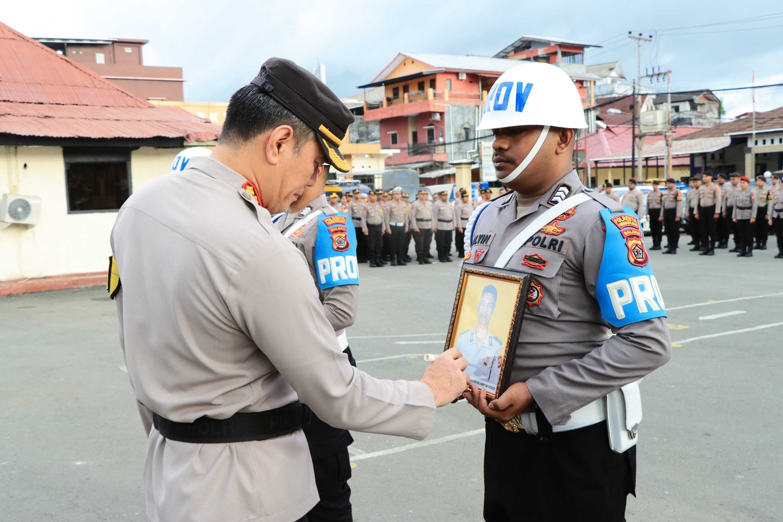 Kapolresta Ambon memberi tanda silang pada foto tiga anggota Polisi yang dipecat.